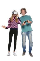 Teenage girl wearing VR headset and mature man with controller playing video games on white background