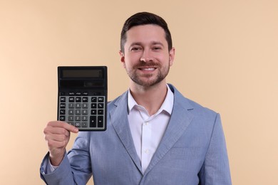 Happy accountant with calculator on beige background