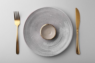 Photo of Setting with stylish cutlery on grey table, top view