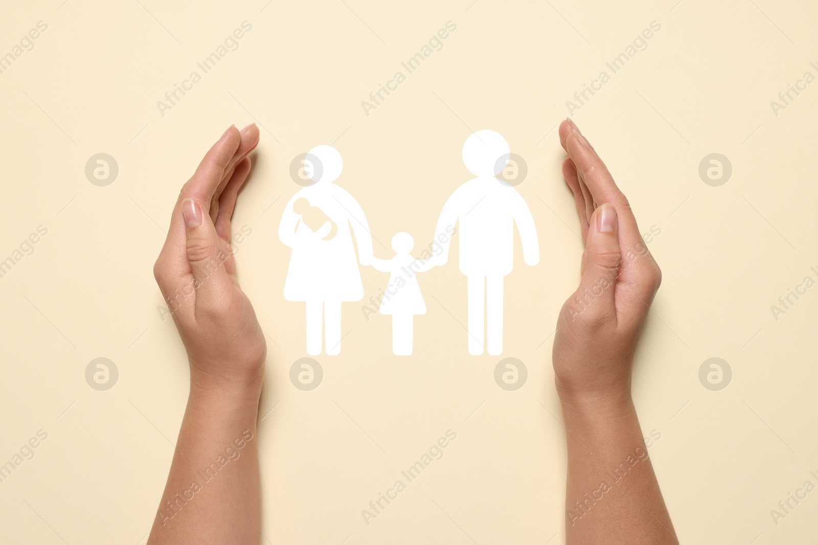 Image of Woman holding hands around paper silhouette of family on beige background, top view. Insurance concept