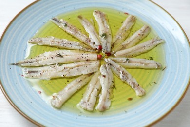 Photo of Tasty pickled anchovies with spices on table, closeup