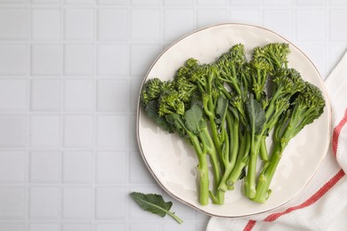 Fresh raw broccolini on white tiled table, top view and space for text. Healthy food