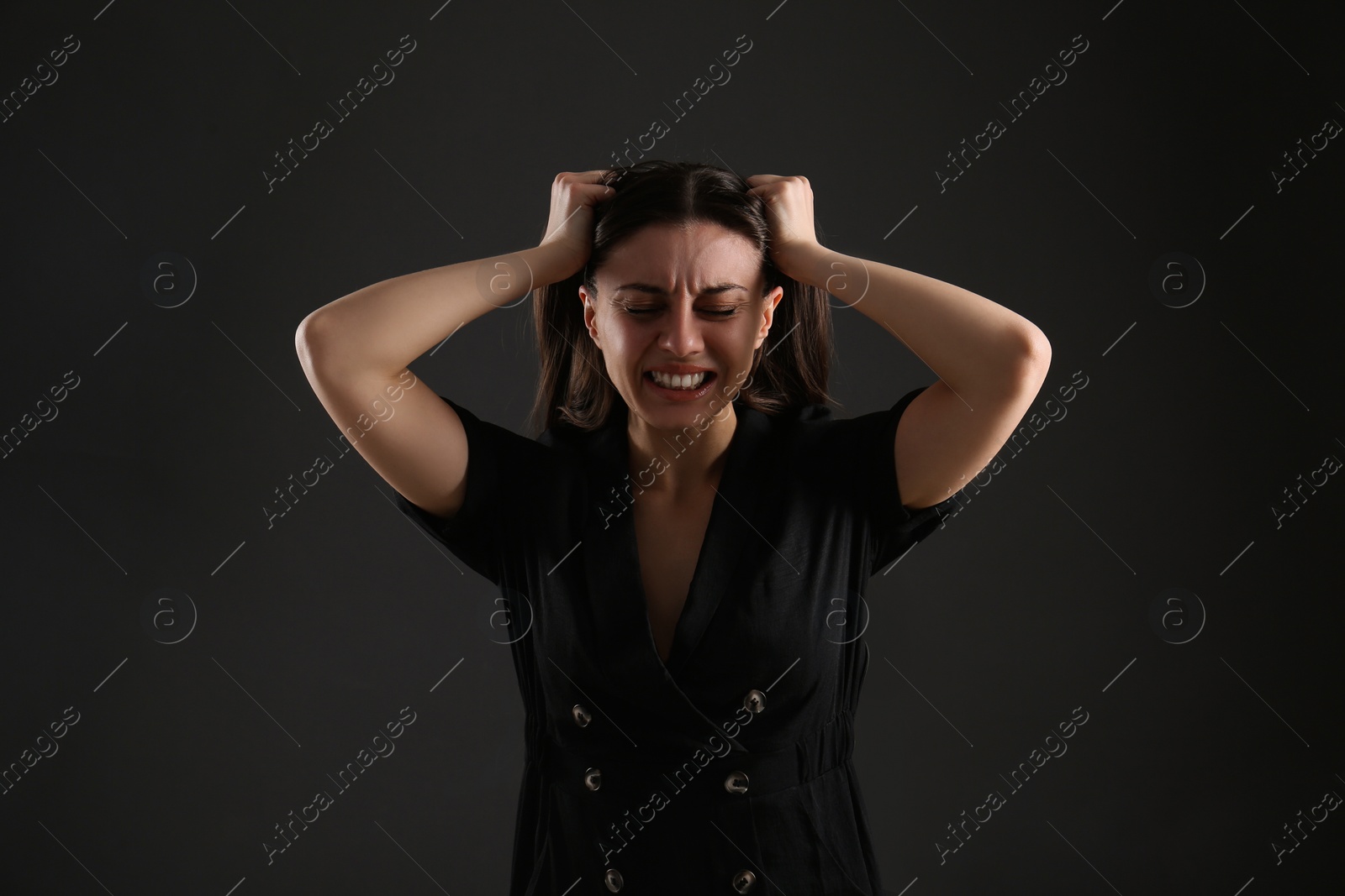 Photo of Portrait of emotional young woman on black background. Personality concept