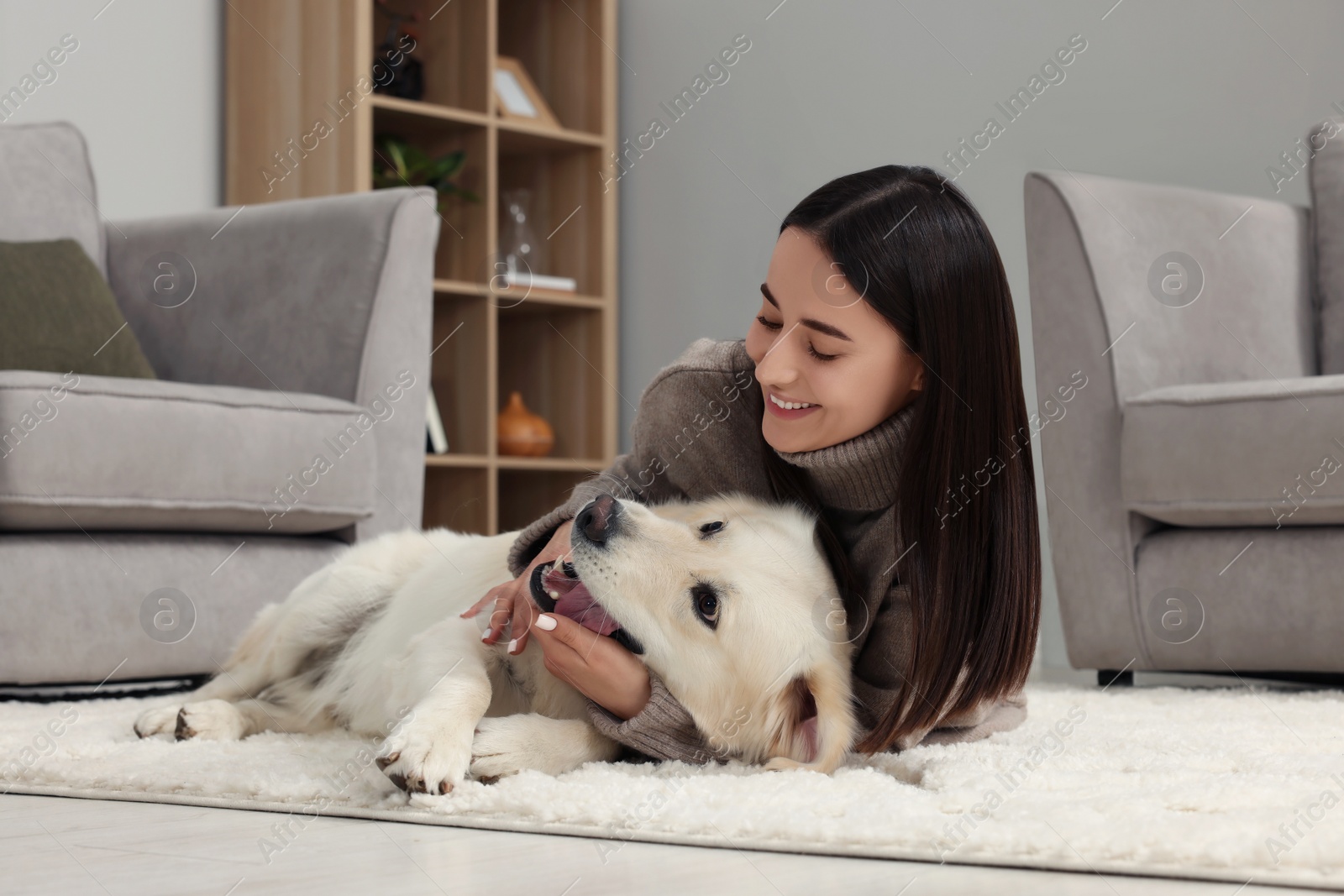 Photo of Happy woman with cute Labrador Retriever dog on floor at home. Adorable pet