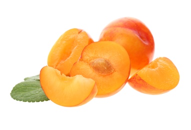 Photo of Whole and cut ripe plums with green leaves isolated on white