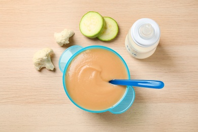 Photo of Healthy baby food and ingredients on wooden table, flat lay