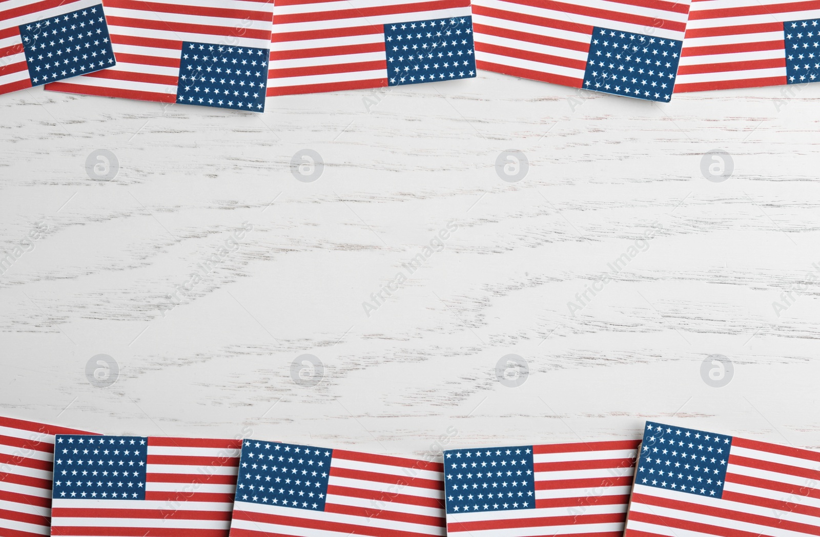 Photo of Flat lay composition of USA flags on wooden table, space for text. Happy Independence Day