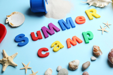 Composition with phrase SUMMER CAMP made of magnet letters on light blue background