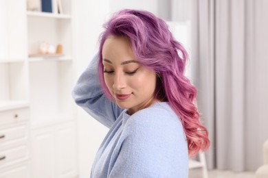Trendy hairstyle. Young woman with colorful dyed hair at home