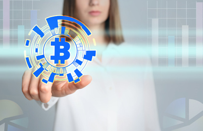 Image of Fintech concept. Woman using virtual screen with bitcoin symbol