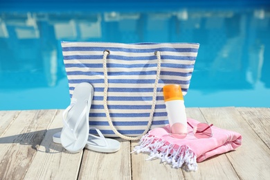 Photo of Beach accessories on wooden deck near outdoor swimming pool