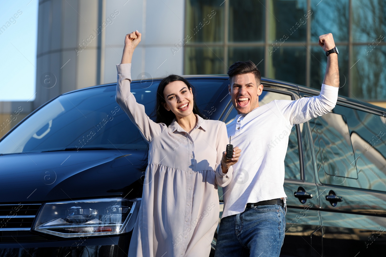 Photo of Excited couple with key near car outdoors. Buying new auto