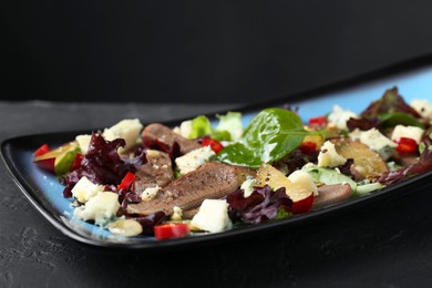Delicious salad with beef tongue and cheese on black table, closeup