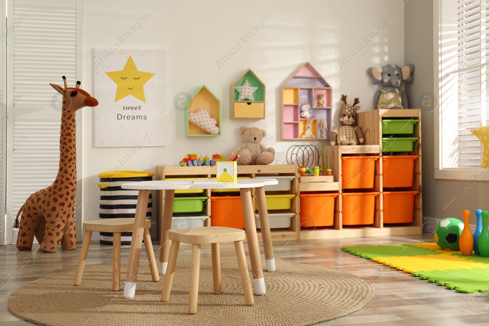 Photo of Stylish playroom interior with soft toys and modern furniture
