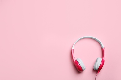 Photo of Stylish headphones on color background, top view. Space for text