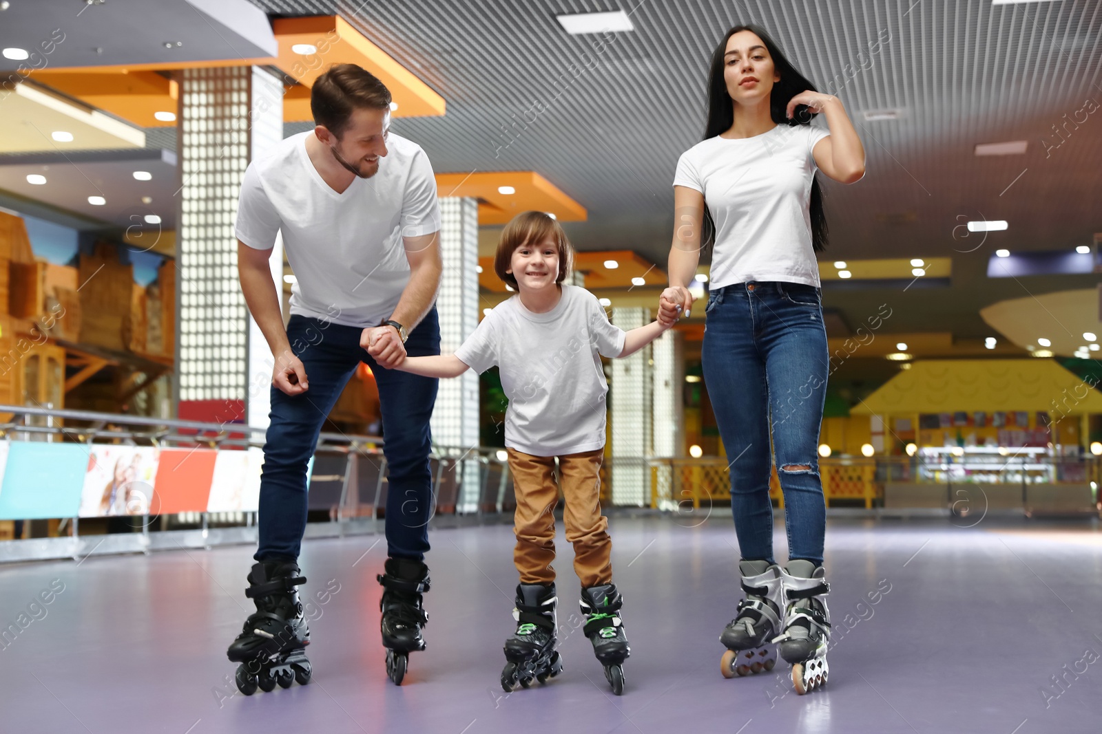 Photo of Happy family spending time at roller skating rink