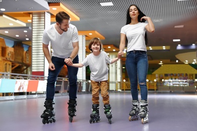 Happy family spending time at roller skating rink