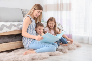 Nanny reading book to little children at home