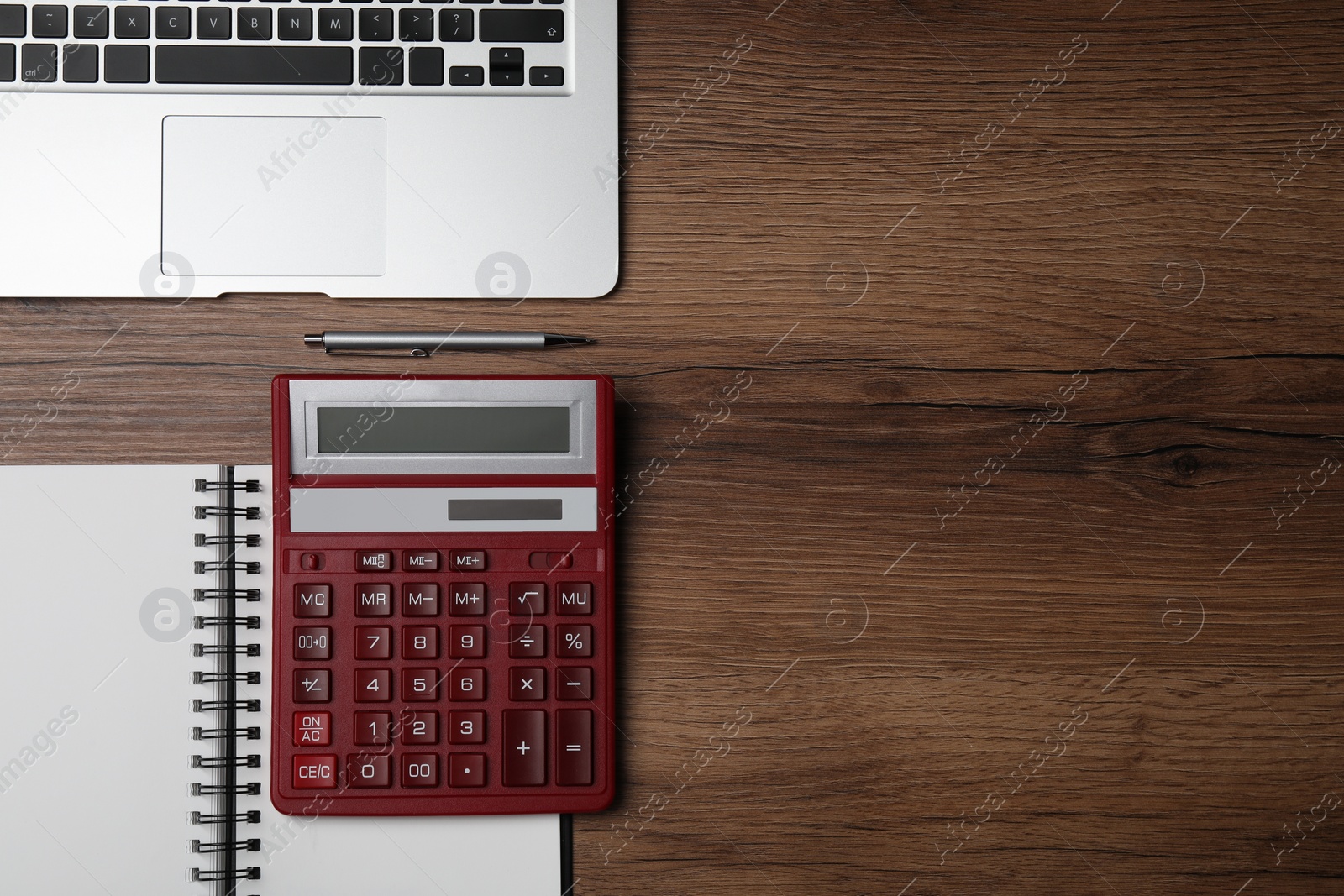 Photo of Calculator, office stationery and laptop on wooden table, flat lay. Space for text