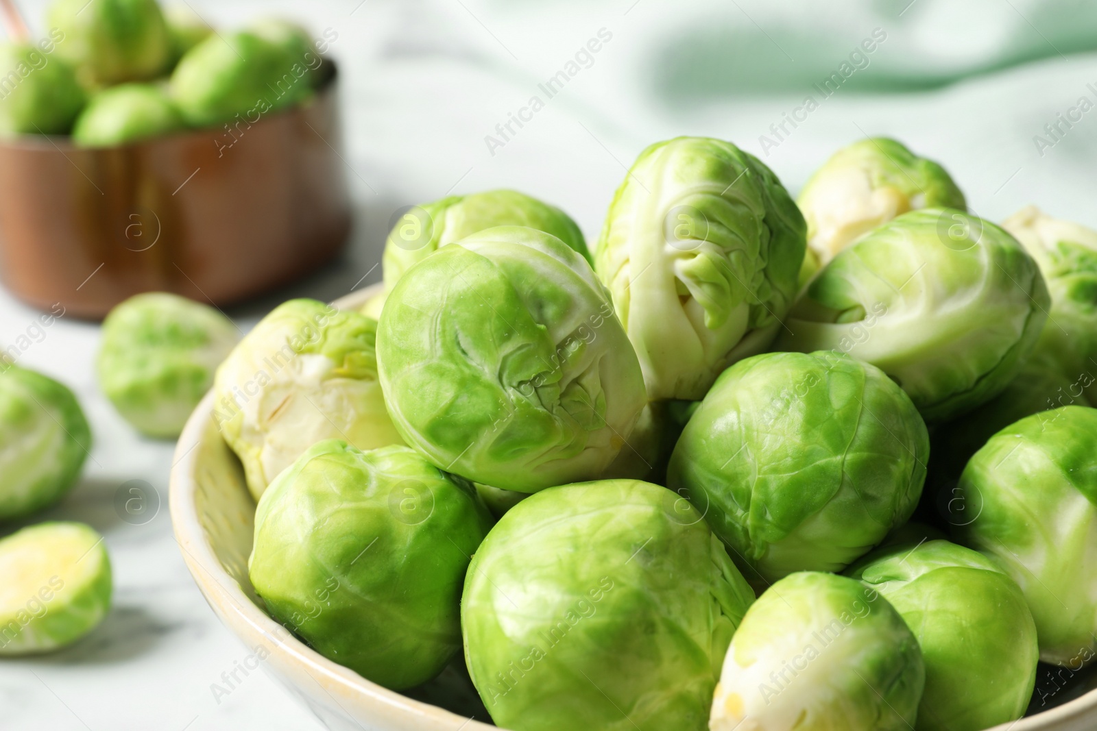 Photo of Bowl with fresh Brussels sprouts on table, closeup