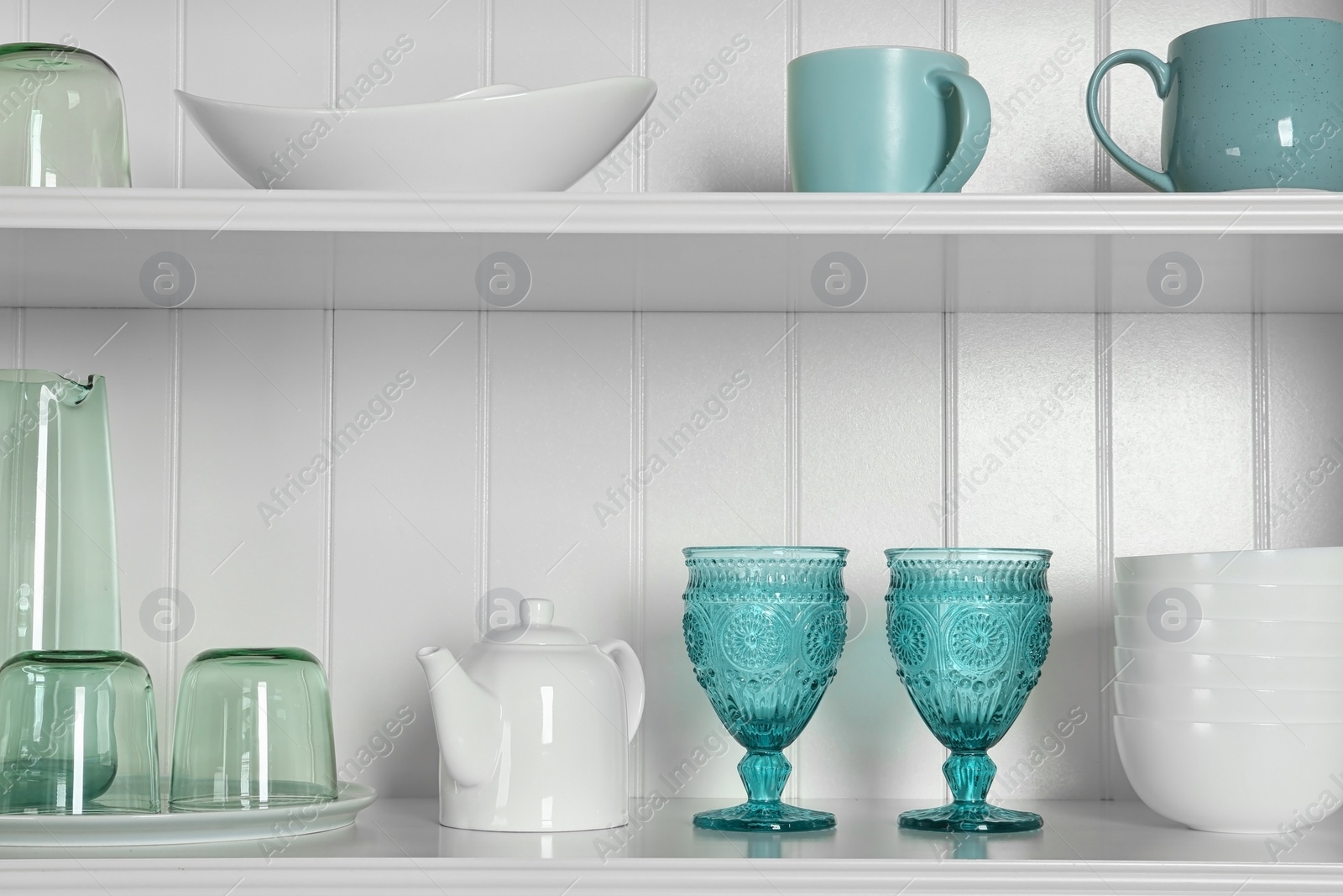 Photo of White shelving unit with set of dishware