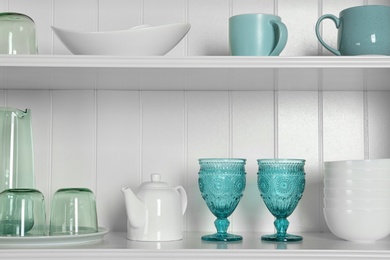 Photo of White shelving unit with set of dishware