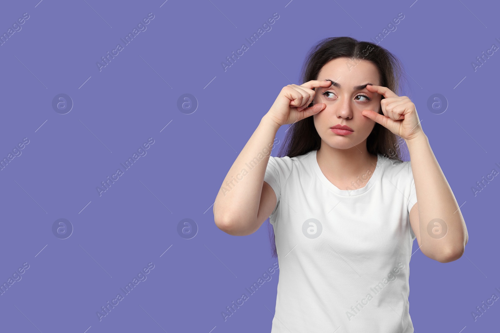 Photo of Tired young woman on purple background, space for text. Insomnia problem