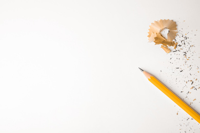 Photo of Pencil and shavings on white background, top view