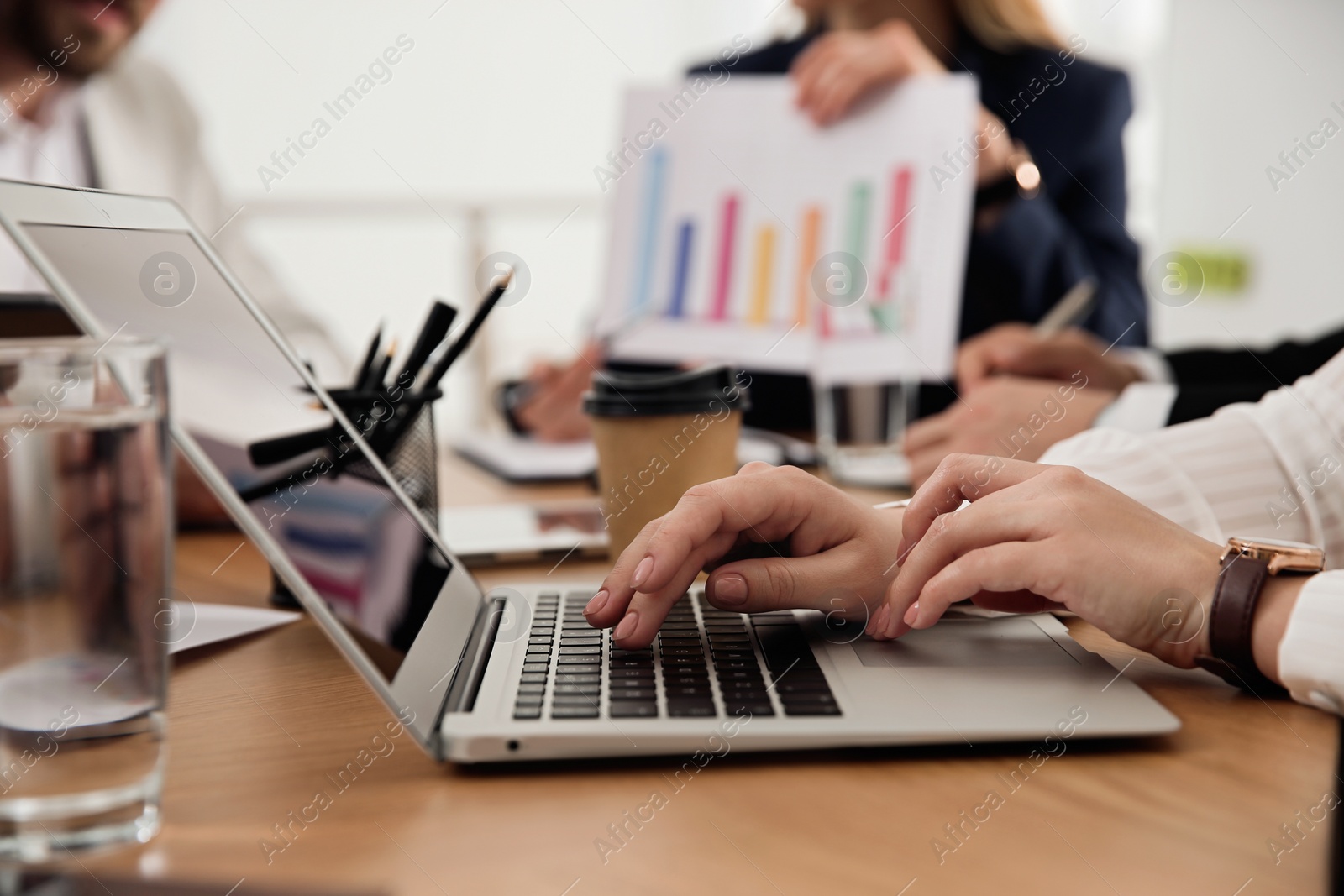 Photo of Woman using laptop at table in office during business meeting, closeup. Management consulting