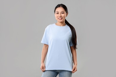 Photo of Woman wearing light blue t-shirt on grey background