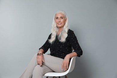 Photo of Portrait of beautiful mature woman on grey background