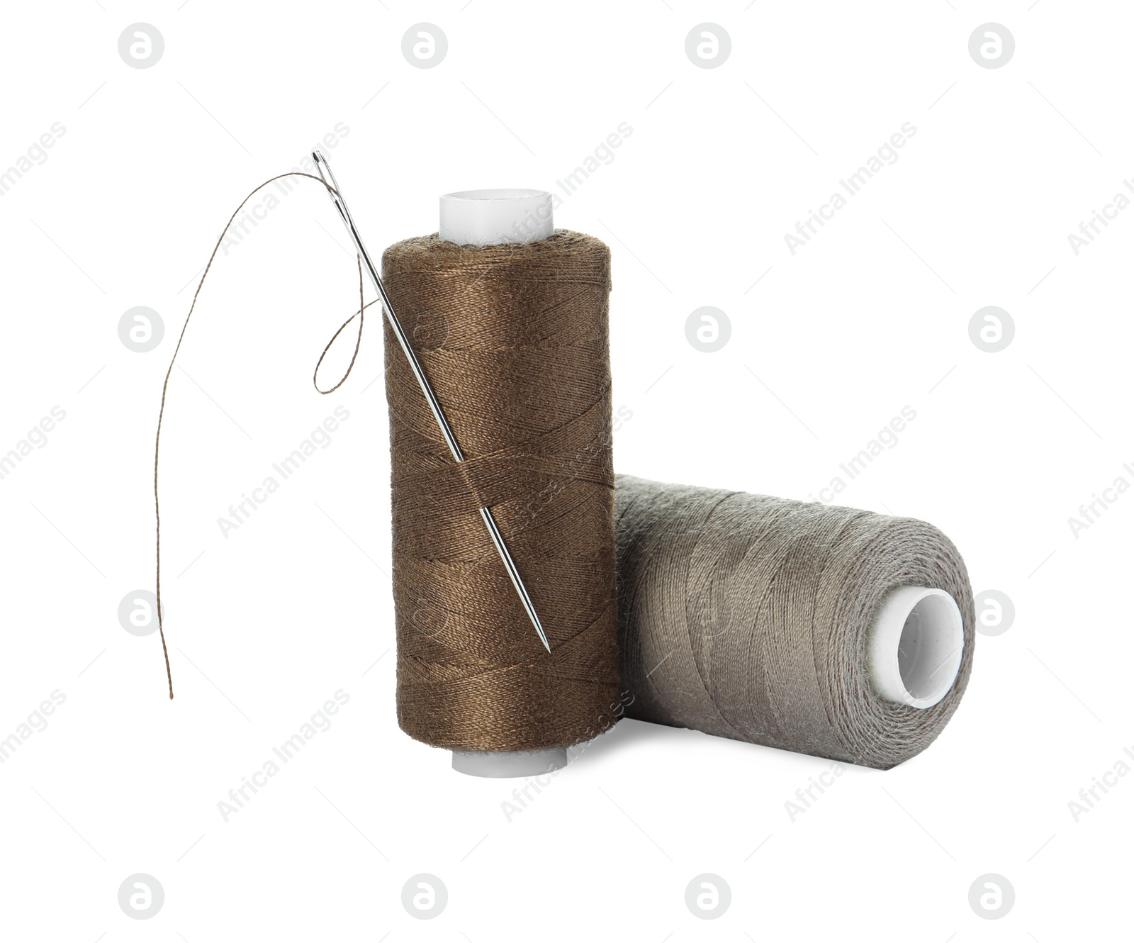 Photo of Different colorful sewing threads and needle on white background