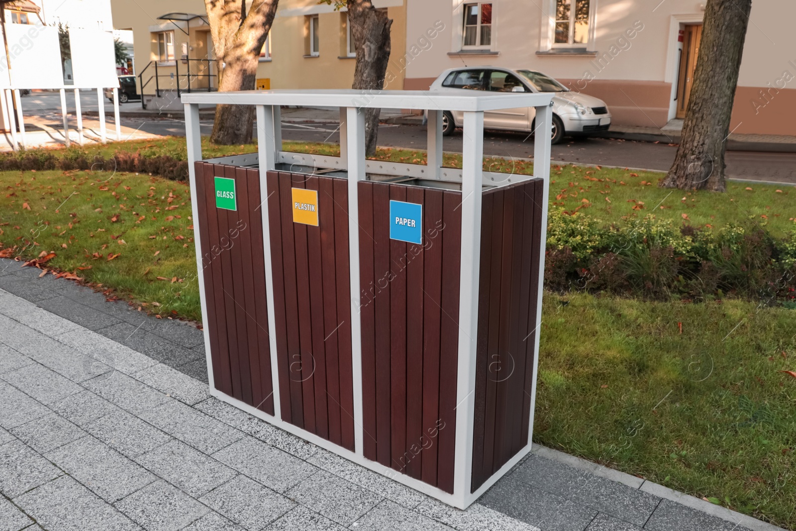 Photo of Different sorting bins for waste recycling on city street outdoors