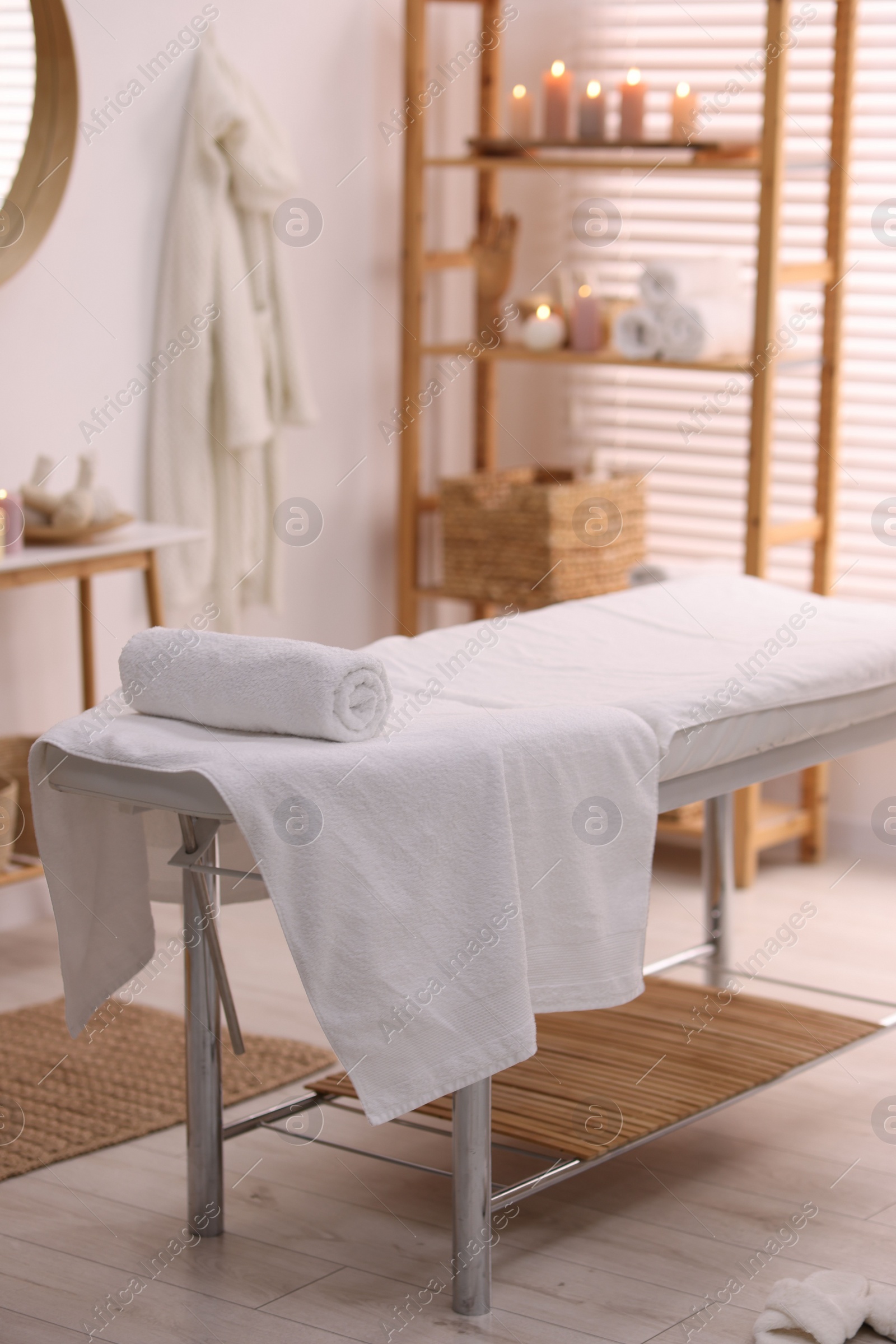 Photo of Comfortable massage table with clean towels in spa center