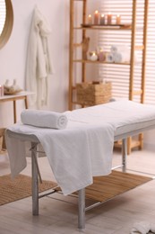 Comfortable massage table with clean towels in spa center