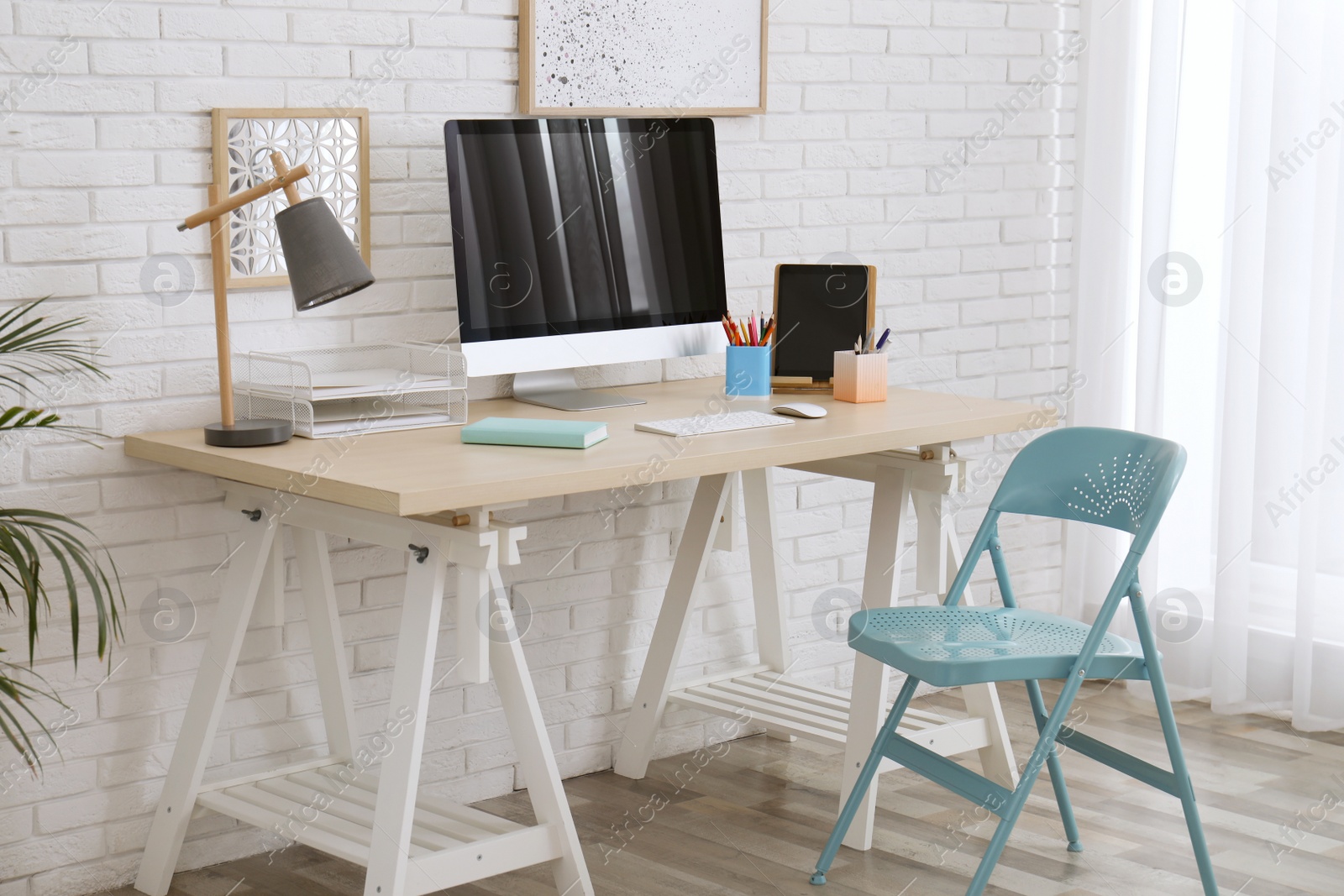 Photo of Stylish home office interior with comfortable workplace near white brick wall