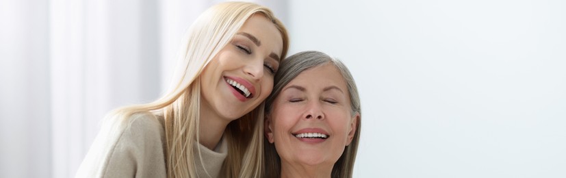 Happy mother and daughter indoors, banner design