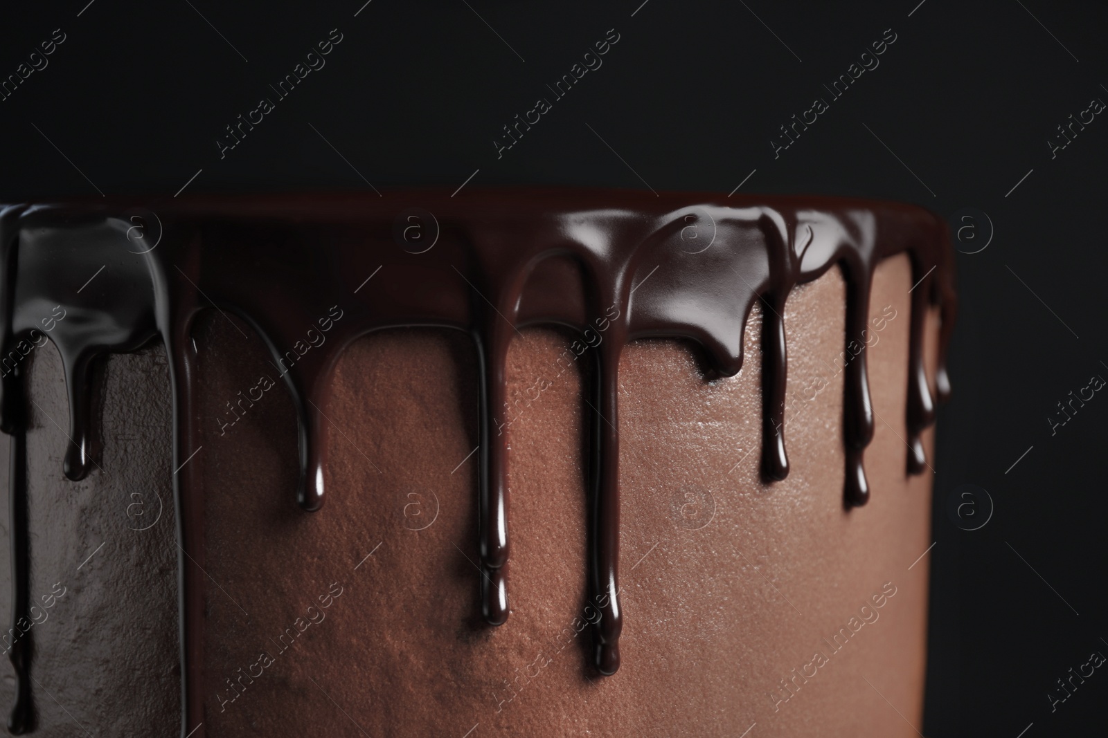 Photo of Freshly made delicious chocolate cake against black background, closeup