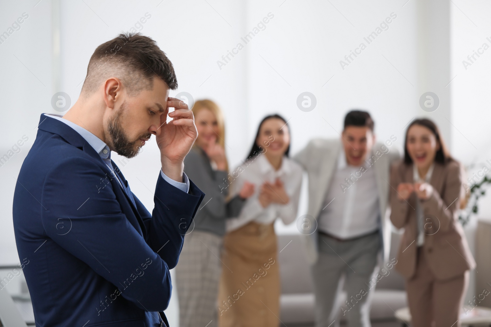 Photo of Coworkers bullying their colleague in office, space for text