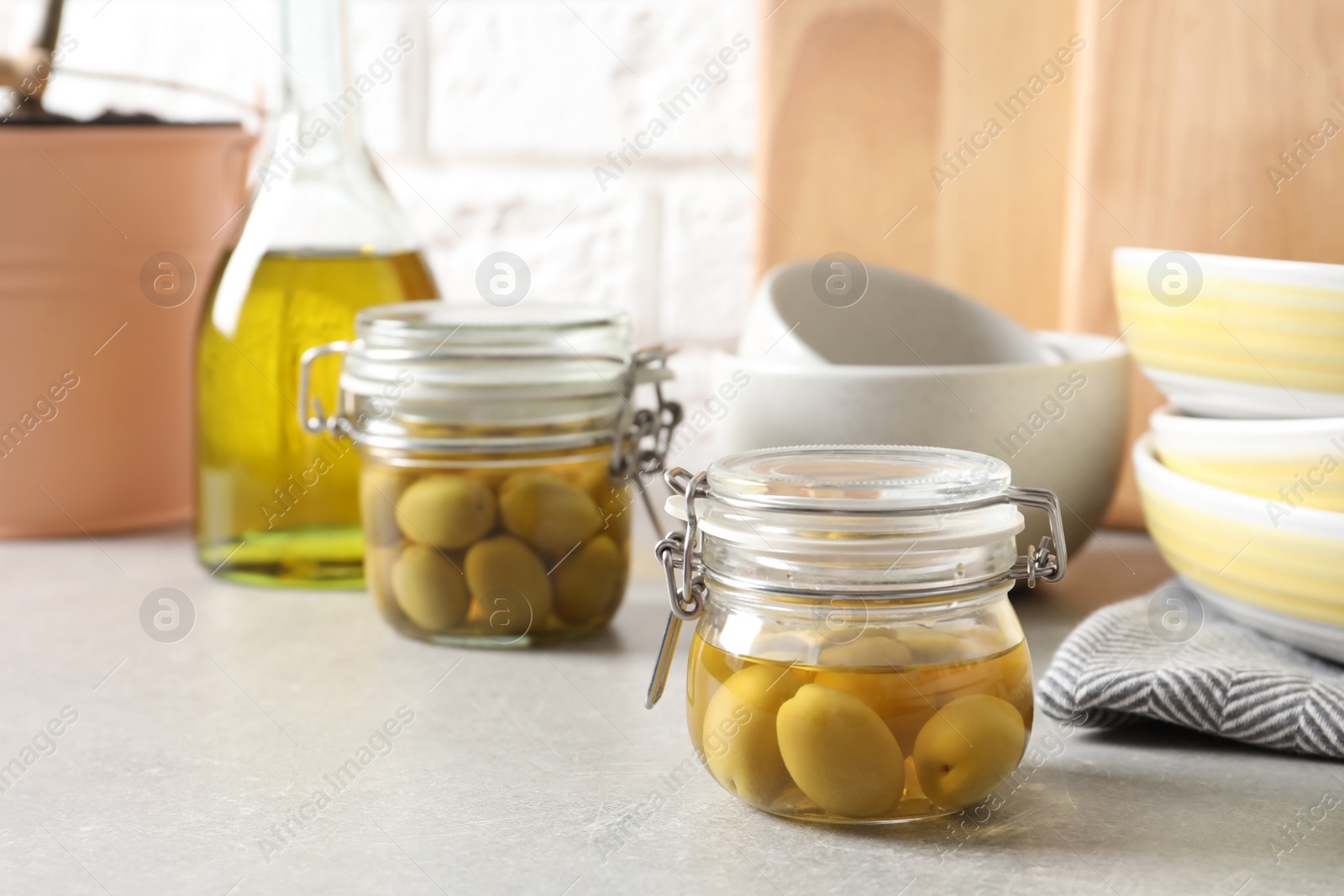 Photo of Olives in fresh oil and dishware on table