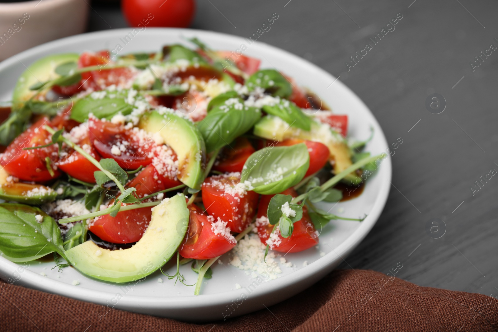 Photo of Tasty salad with balsamic vinegar on grey wooden table, closeup