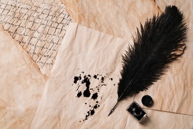 Photo of Open inkwell and lush feather pen on vintage parchments, flat lay. Space for text