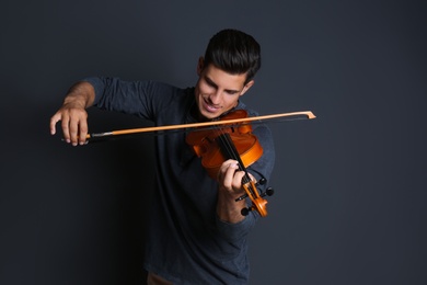 Photo of Happy man playing violin on black background