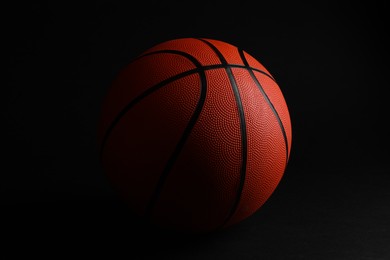 Photo of One new basketball ball on black background