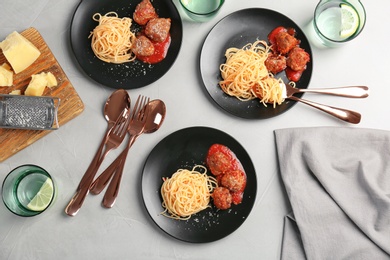 Photo of Delicious pasta with meatballs and tomato sauce on grey background