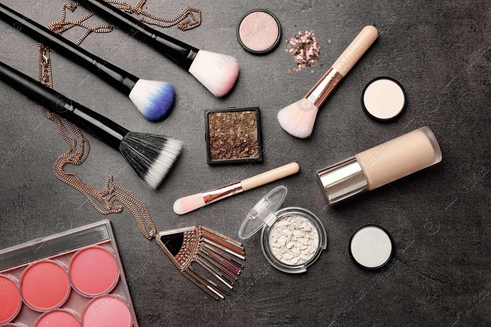 Photo of Flat lay composition with cosmetic products and makeup brushes on grey background