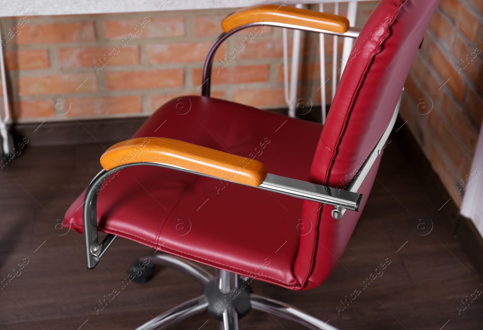 Photo of Comfortable red desk chair in modern office, closeup