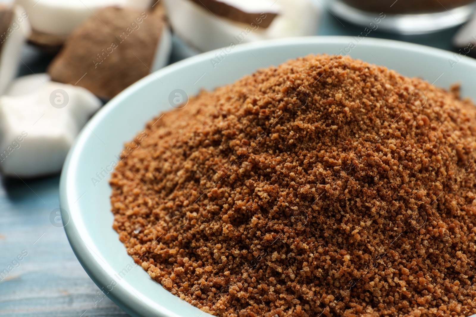 Photo of Natural coconut sugar in ceramic bowl, closeup