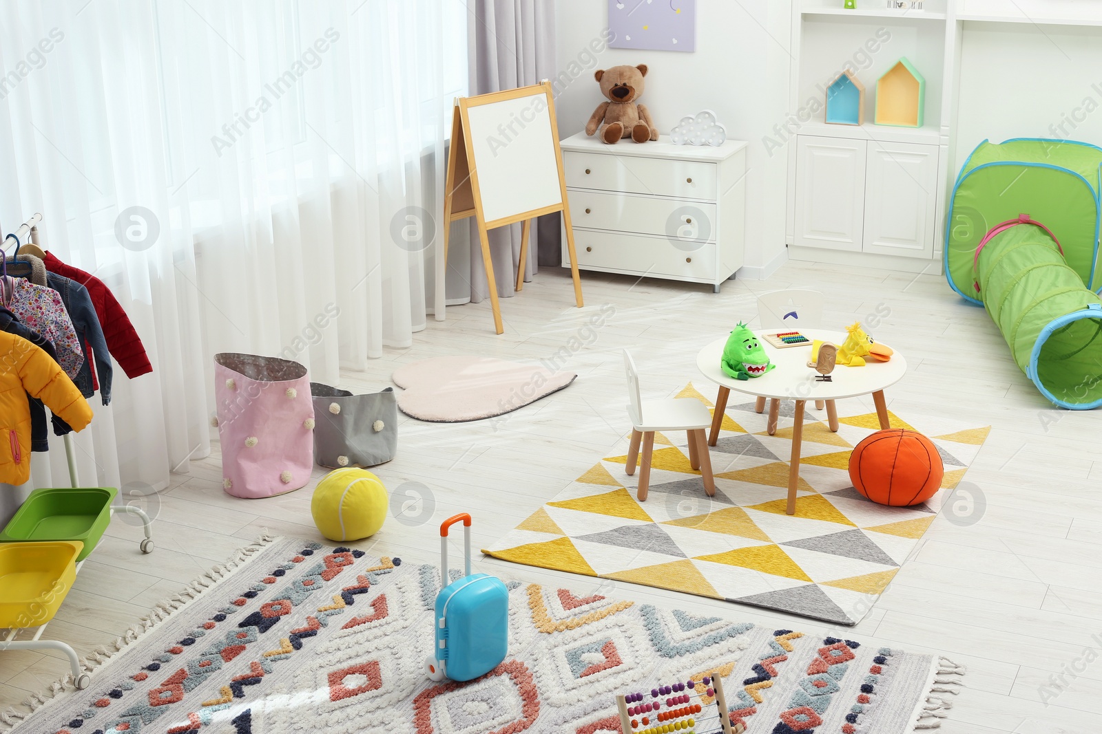 Photo of Child`s playroom with different toys and modern furniture. Stylish kindergarten interior