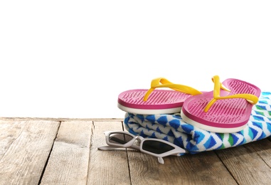 Photo of Towel, shoes and sunglasses on wooden table, space for text. Beach accessories